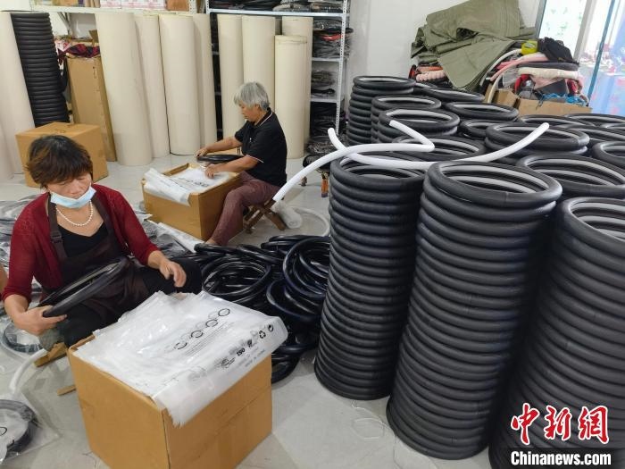 圖為村民在汽車飾品企業(yè)生產(chǎn)車間中工作?！巫雍?攝