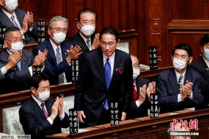 當?shù)貢r間10月4日，日本自民黨總裁岸田文雄經(jīng)過眾院全體會議的首相指名選舉成為第100任首相。圖為岸田文雄（中）起身致謝。