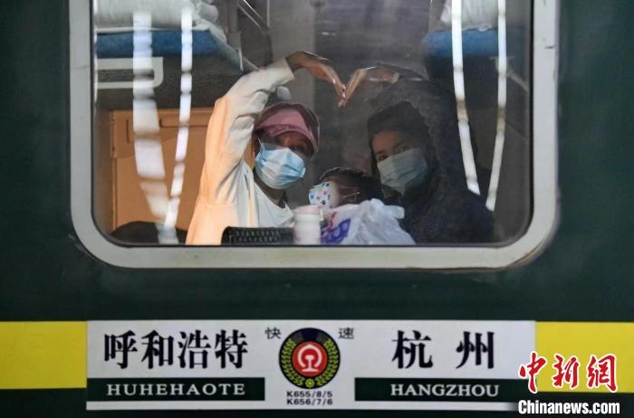 圖為登上轉(zhuǎn)運(yùn)火車的游客向額濟(jì)納比心?！⊥趵?攝