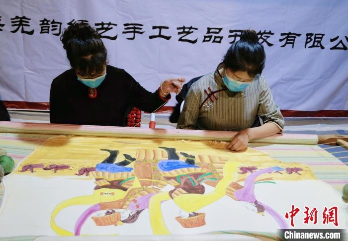 圖為皮繡藝人在市集上“秀”指尖技藝?！●R銘言 攝