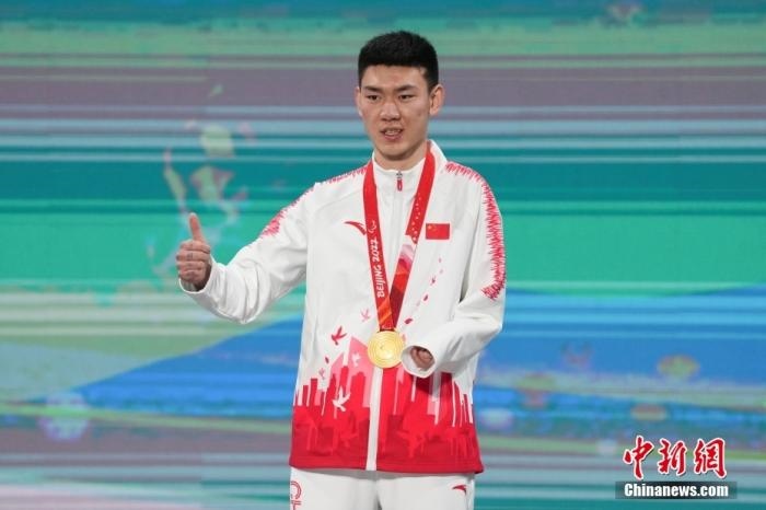 3月6日，梁景怡在延慶頒獎(jiǎng)廣場(chǎng)領(lǐng)獎(jiǎng)臺(tái)上豎起大拇指。當(dāng)日，在國(guó)家高山滑雪中心舉行的北京2022年冬殘奧會(huì)殘奧高山滑雪男子超級(jí)大回轉(zhuǎn)—站姿決賽中，中國(guó)選手梁景怡奪得冠軍。 <a target='_blank' href='/'>中新社</a>記者 楊華峰 攝