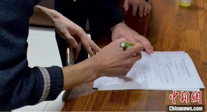 圖為現(xiàn)場下達詢問通知書。　李婷婷 攝