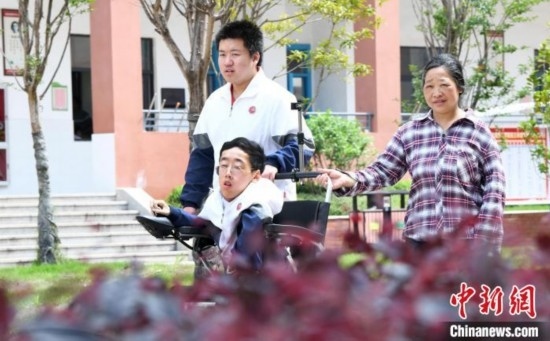 碰上天氣好，朱金祥就會利用休息時間，和鐘華強母親將其推出來賞賞花，曬曬太陽，呼吸一下外面的新鮮空氣。 卓忠偉 攝