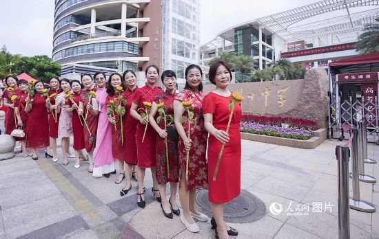 6月7日一早，廈門雙十中學(xué)考生家長們身穿旗袍，手拿向日葵在考場外為孩子加油打氣，寓意“旗開得勝，一舉奪魁”。人民網(wǎng)記者 陳博攝
