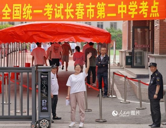6月7日，在長春市第二中學(xué)考點，一名考生信心滿滿進入考場，并與家長揮手致意。人民網(wǎng)記者 李洋攝