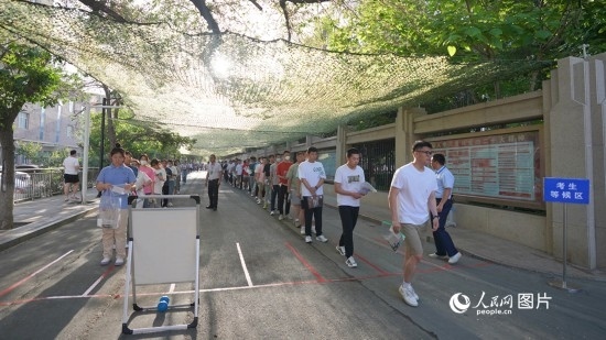 6月7日，烏魯木齊市第七十中學(xué)門口，考生們有序進入考場。人民網(wǎng) 李欣洋攝