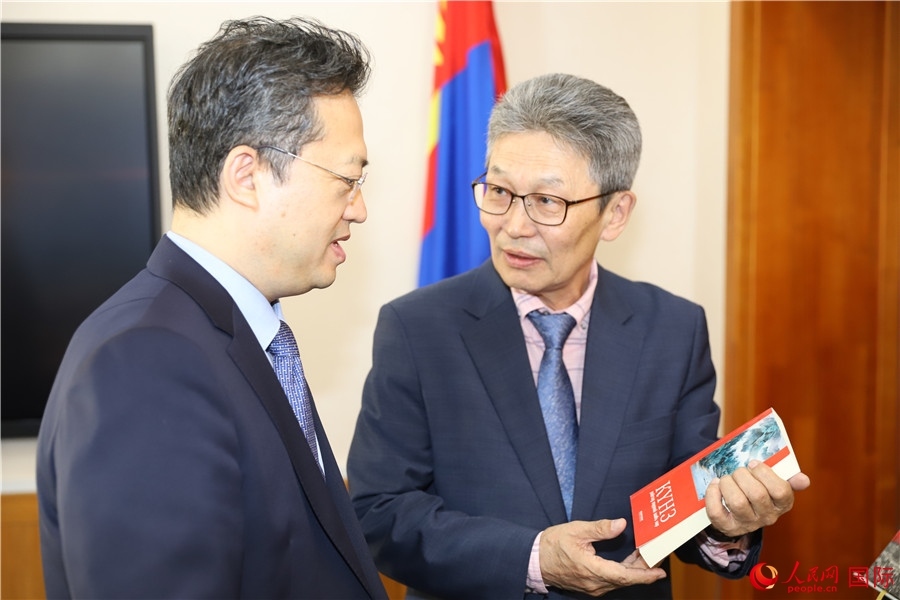 其米德策耶（右一）向李峙介紹翻譯成果。人民網(wǎng)記者 霍文攝