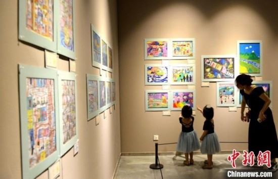 圖為家長(zhǎng)帶著孩子參觀展覽。呂明 攝