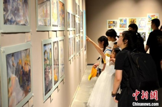 圖為家長(zhǎng)帶著孩子參觀展覽。呂明 攝