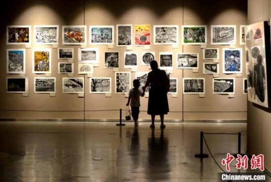 圖為家長(zhǎng)帶著孩子參觀展覽。呂明 攝