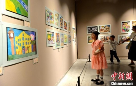 圖為家長(zhǎng)帶著孩子參觀展覽。呂明 攝