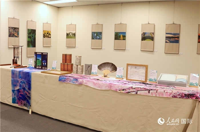 現(xiàn)場展出的馮學(xué)敏攝影作品與湖州市特色工藝品。（人民網(wǎng) 許可攝）