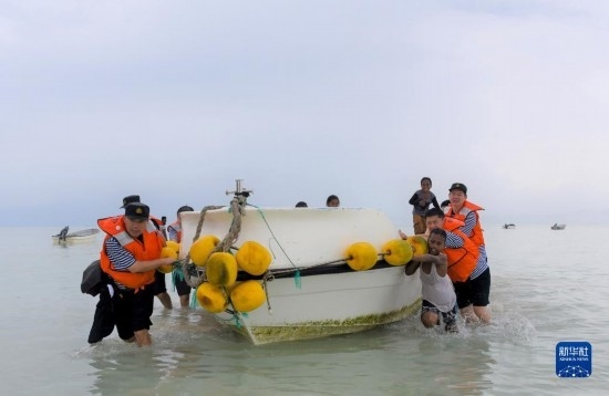 7月21日，中國海軍“和平方舟”號醫(yī)院船醫(yī)護人員涉水登島，前往基里巴斯一診療點。新華社記者 黎云 攝