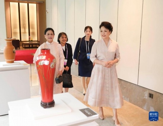 7月27日下午，國家主席習近平夫人彭麗媛在四川成都會見陪同印度尼西亞總統(tǒng)佐科來華出席第31屆世界大學生夏季運動會開幕式并訪華的總統(tǒng)夫人伊莉亞娜。這是彭麗媛和伊莉亞娜欣賞成都特色非遺工藝品。新華社記者 丁林 攝