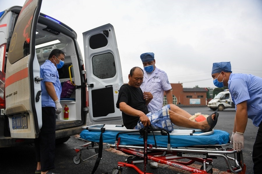 8月1日，在北京市門頭溝區(qū)妙峰山鎮(zhèn)妙峰山民族學校臨時安置點，北京急救中心工作人員在轉(zhuǎn)運一名受傷村民。新華社記者 鞠煥宗 攝