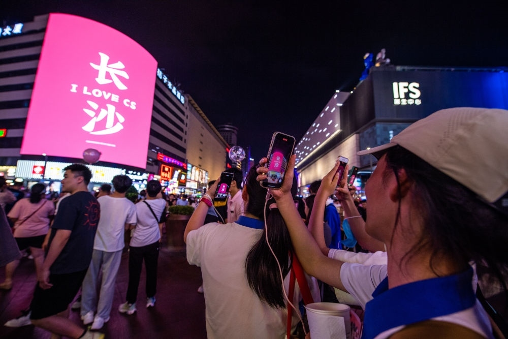  游客在長(zhǎng)沙市天心區(qū)黃興路步行街打卡、拍照（6月7日攝）。新華社記者 陳思汗 攝