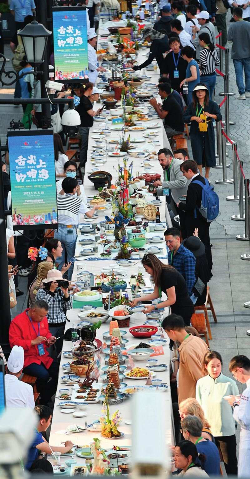 市民和游客在寧波舉辦的第三屆中國—中東歐國家博覽會暨國際消費(fèi)品博覽會上品嘗融合中國和中東歐美食的長桌宴（2023年5月15日攝）。黃宗治攝/本刊