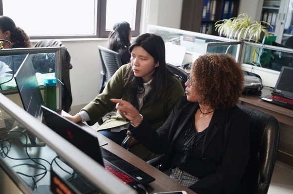 梅德哈妮（右）與中國同事討論設(shè)計方案。受訪對象供圖