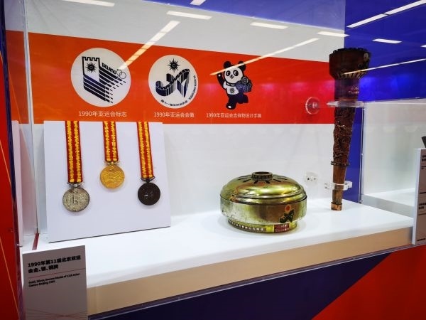 1990年北京亞運(yùn)會(huì)獎(jiǎng)牌、火種盒、火炬等展品。 人民網(wǎng)記者 楊磊攝