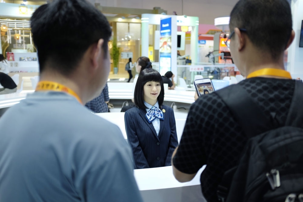 9月1日，媒體記者在國家會議中心與服務機器人互動。新華社記者 劉夢琪 攝