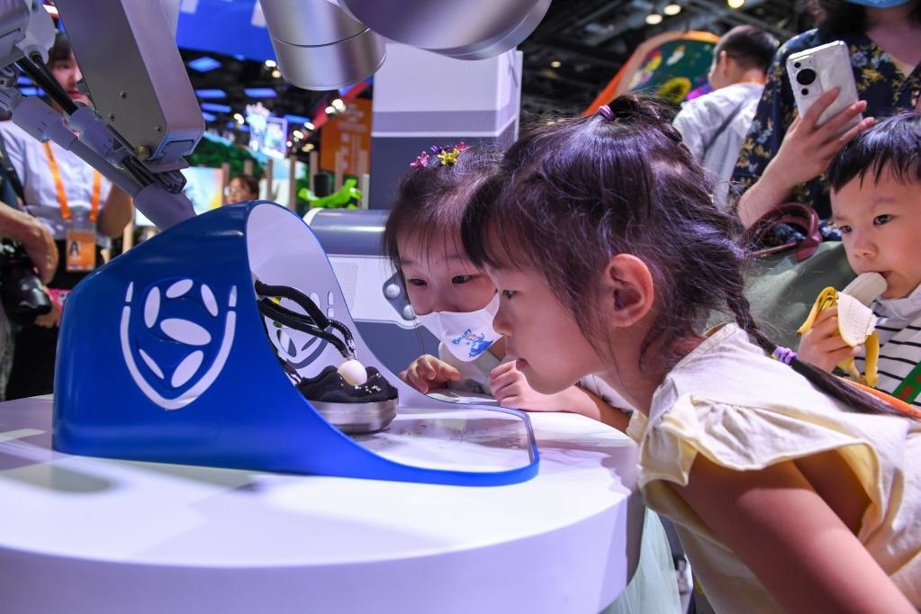 9月3日，幾名小朋友在國家會議中心觀看單孔腔鏡手術機器人展示。新華社記者 鞠煥宗 攝