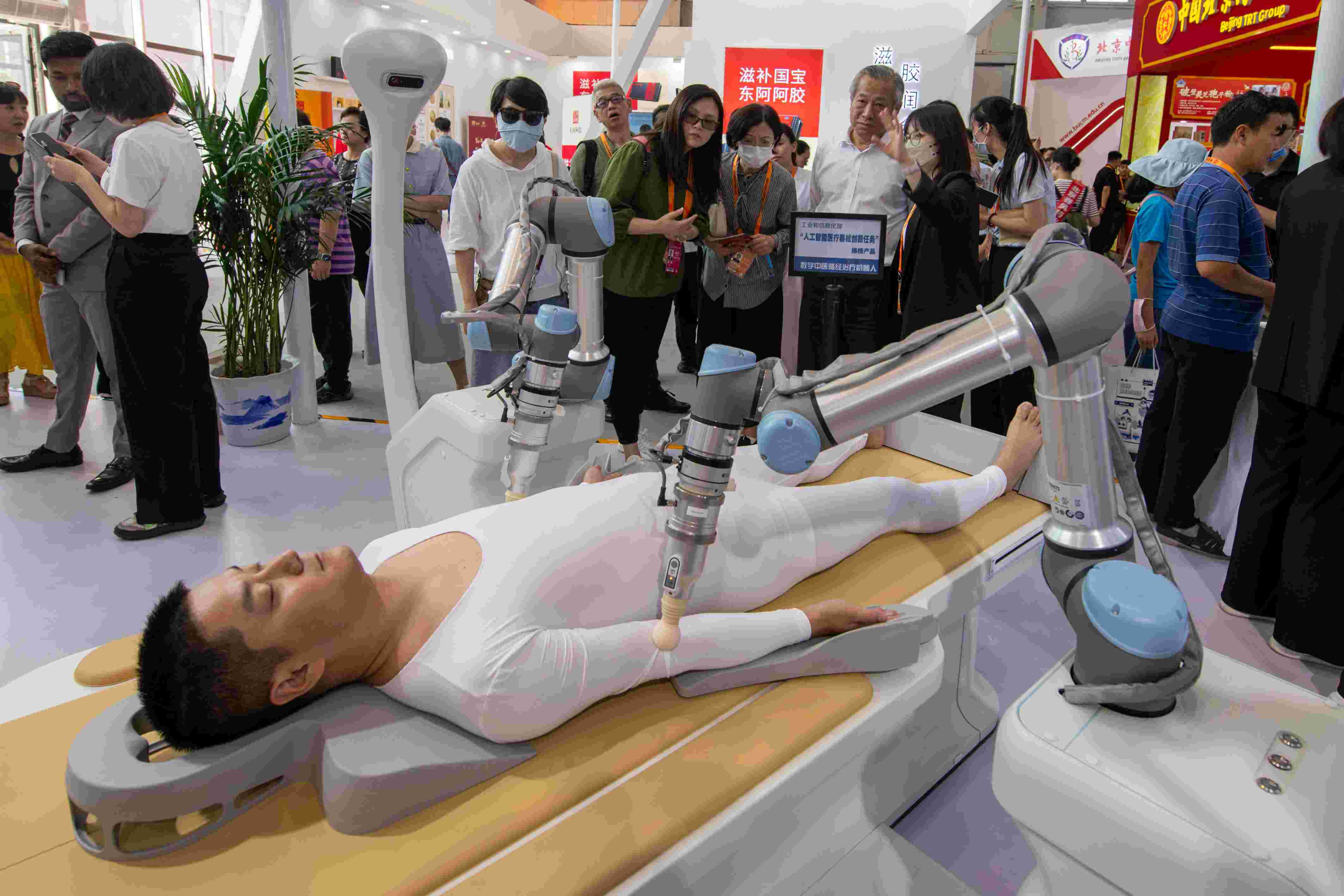 在位于首鋼園的健康衛(wèi)生服務(wù)展區(qū)，觀眾正在參觀數(shù)字中醫(yī)循經(jīng)治療機(jī)器人。人民網(wǎng)記者 翁奇羽攝