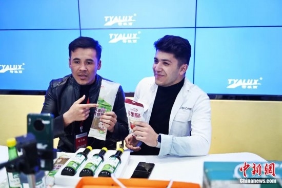 2023年3月，甘肅省慶陽市環(huán)縣電商創(chuàng)業(yè)孵化基地內(nèi)，來自蘭州文理學(xué)院的塔吉克斯坦留學(xué)生正在協(xié)助主播直播帶貨當(dāng)?shù)剞r(nóng)特產(chǎn)品。李亞龍 攝