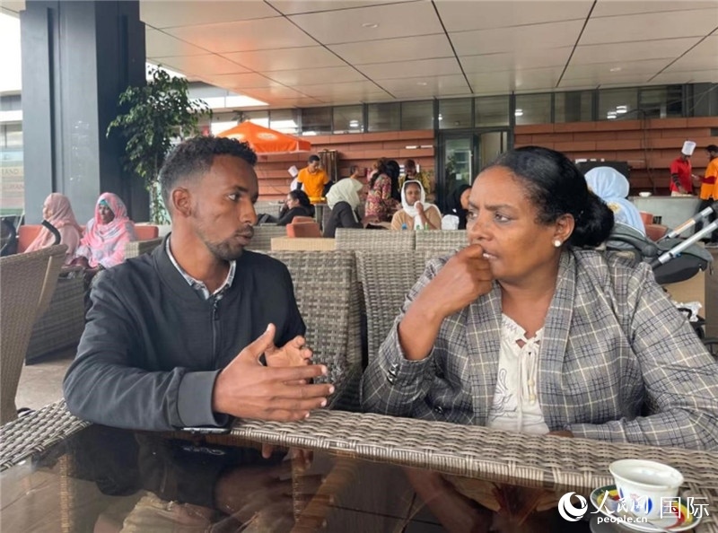 約漢斯（圖左）與德貝拉在友誼廣場咖啡廳交談。人民網(wǎng)記者 趙艷紅攝