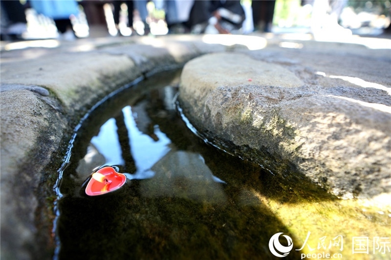 圖為水渠里流過的“桃心”蠟燭。人民網(wǎng) 盧鵬宇攝