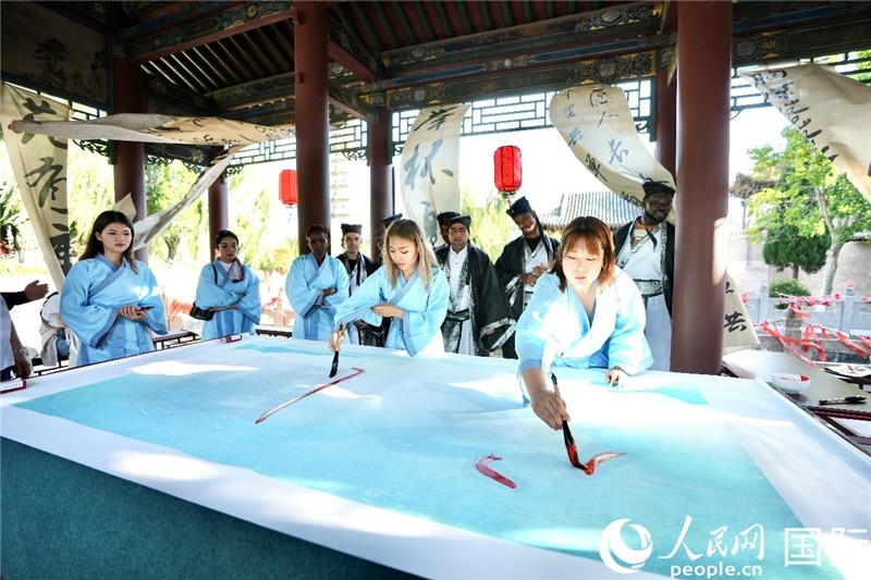 選手們提筆書寫“家園”二字。人民網(wǎng) 盧鵬宇攝