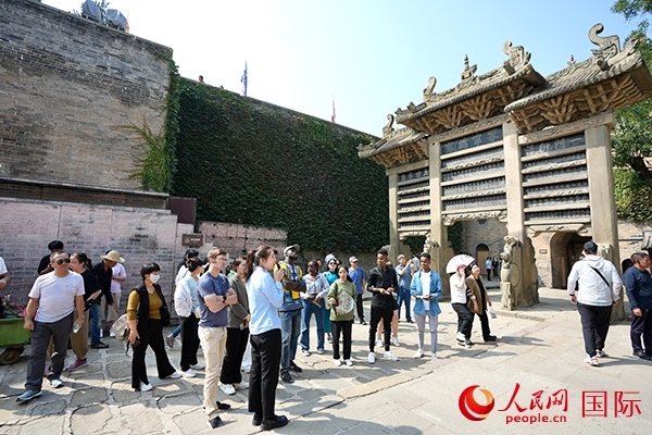 選手們認(rèn)真聆聽導(dǎo)游講解。人民網(wǎng) 盧鵬宇攝