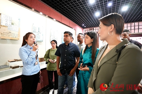 選手們認(rèn)真聆聽導(dǎo)游講解。人民網(wǎng) 盧鵬宇攝