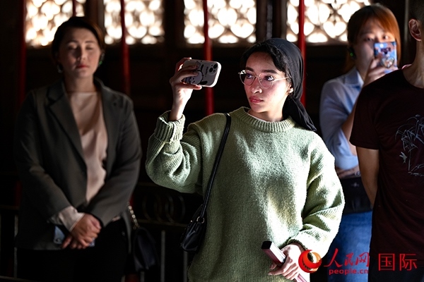 選手顏青（蘇丹）用手機(jī)記錄所見所感。人民網(wǎng) 盧鵬宇攝