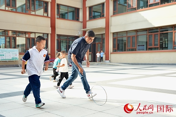 來(lái)自巴基斯坦的沙杰在滾鐵環(huán)。人民網(wǎng) 盧鵬宇攝