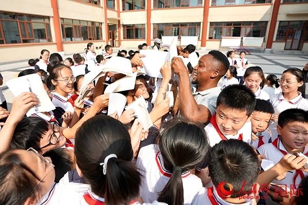 孩子們和選手互動(dòng)簽名。人民網(wǎng) 盧鵬宇攝