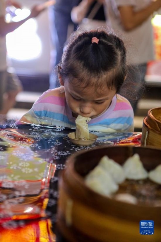 9月27日，小朋友在南翔小籠長街宴上品嘗南翔小籠。