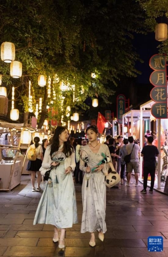 在成都寬窄巷子，兩位來(lái)自安徽的游客在新“十二月市”街區(qū)游覽（9月29日攝）。