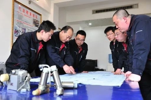 △李志強(qiáng)（左二）與班組成員在研究工作。