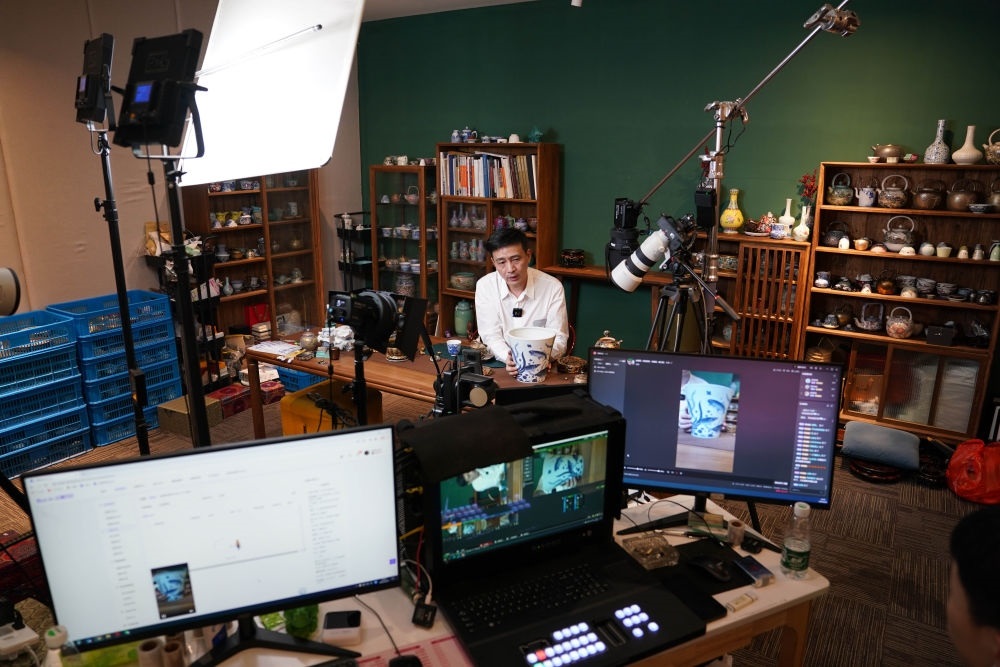 ↑在景德鎮(zhèn)，工作人員通過(guò)網(wǎng)絡(luò)直播推介陶瓷產(chǎn)品（2023年2月22日攝）。