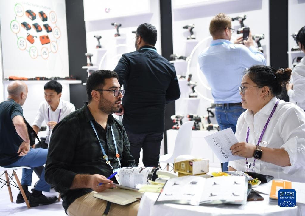 10月15日，在一家電動工具展臺，外國采購商在洽談業(yè)務(wù)。新華社記者 鄧華 攝