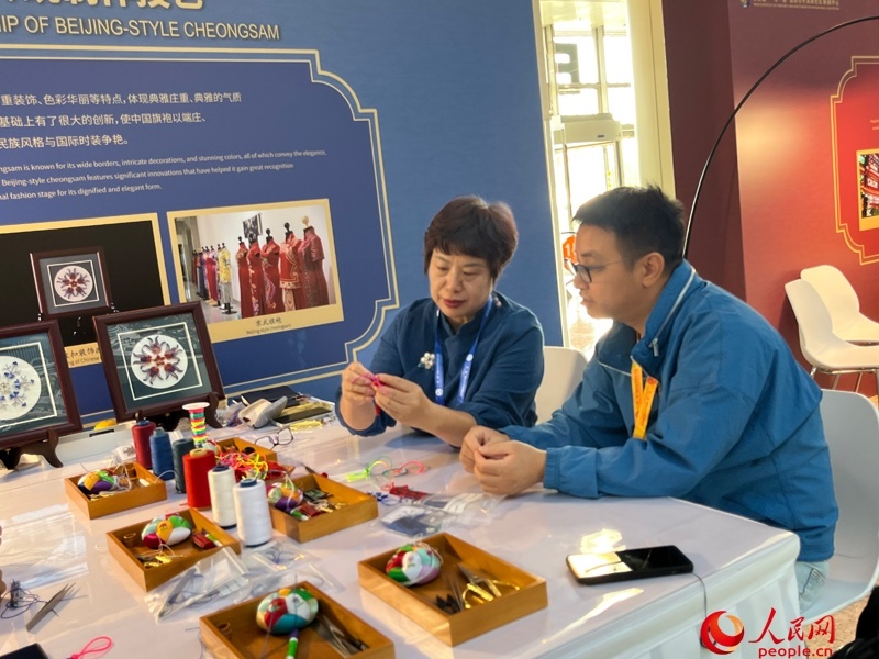 記者在新聞中心非遺傳承人展區(qū)進(jìn)行體驗(yàn)。人民網(wǎng)記者 杜燕飛攝