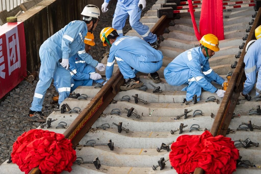 3月31日，在印度尼西亞雅加達(dá)雅萬高鐵哈利姆車站，工人鋪設(shè)雅萬高鐵全線最后一根鋼軌。