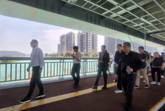 10月24日，2023“一帶一路”媒體合作論壇聯(lián)合采訪團(tuán)團(tuán)員走在清水塘大橋景觀通道上。本報(bào)記者 常雯宜攝