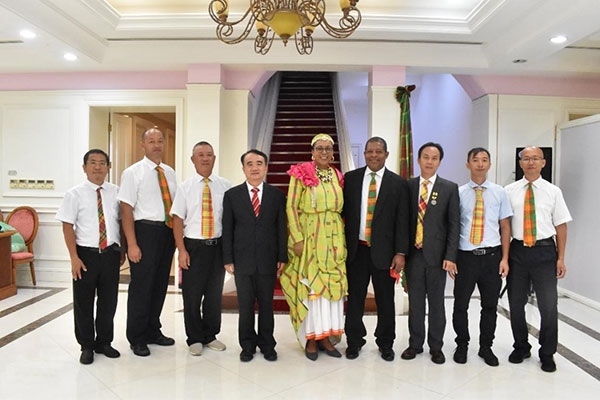 多米尼克總統(tǒng)伯頓和駐多米尼克大使林先江與中國(guó)農(nóng)業(yè)技術(shù)專家組合影。中國(guó)駐多米尼克大使館供圖