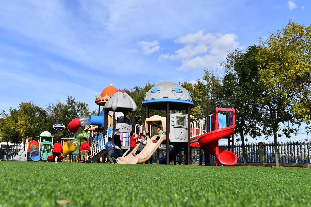 在山東省東營市墾利區(qū)楊廟社區(qū)幼兒園，孩子們在老師的帶領(lǐng)下進(jìn)行戶外活動（2021年10月19日攝）。新華社記者 郭緒雷 攝