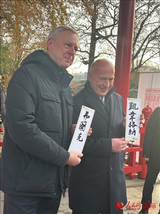 柏林市長韋格納（右）、動(dòng)物園監(jiān)事會(huì)主席布魯克曼（左）手持中國文化中心工作人員現(xiàn)場手書的中文名字。人民網(wǎng)記者 徐馨攝