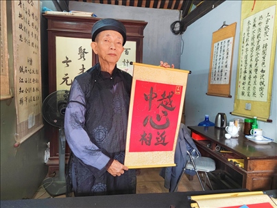 越南首都河內(nèi)文廟內(nèi)，阮明珠展示“中越心相近”書法作品。