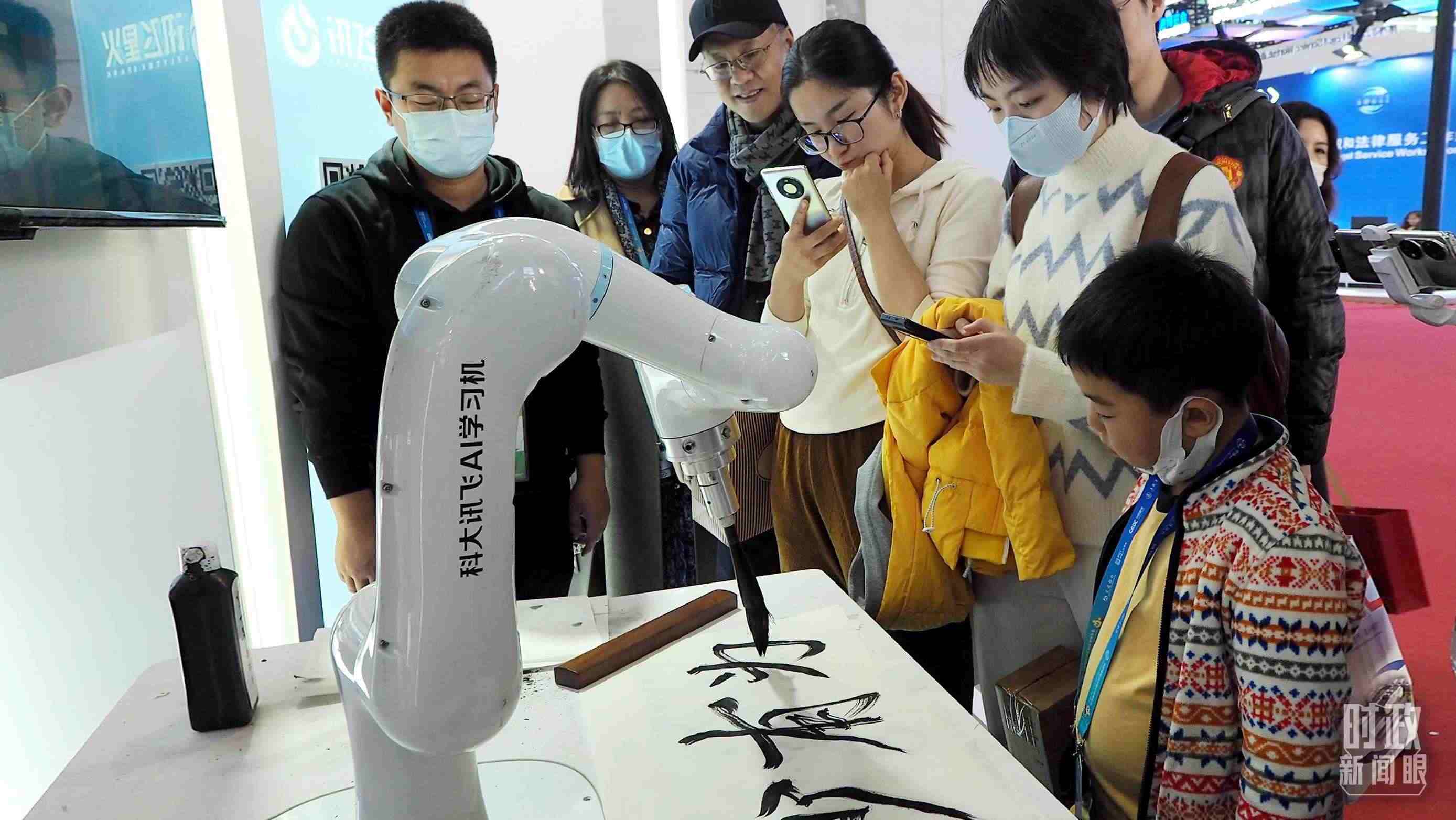 △觀眾在首屆鏈博會上體驗AI書法機器人。