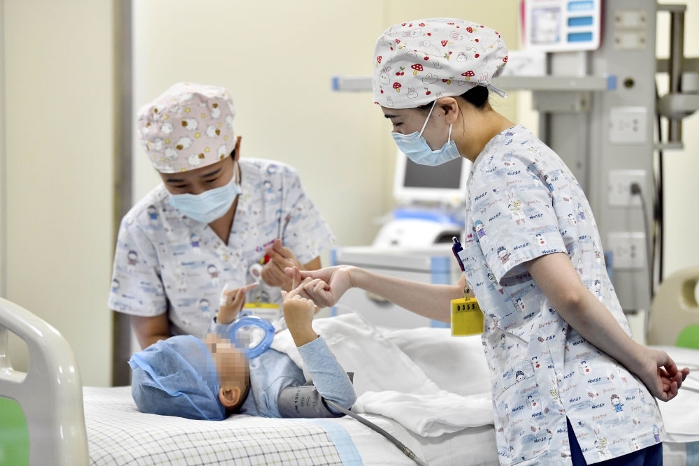 在山東省棗莊市婦幼保健院兒童ICU病房，醫(yī)護(hù)人員為完成靶向治療藥物諾西那生鈉的4歲脊髓性肌萎縮癥患兒加油鼓勁（2022年1月1日攝）。諾西那生鈉注射液是我國首個獲批治療脊髓性肌萎縮癥的進(jìn)口藥物，2019年進(jìn)入中國市場時，每針價格近70萬元。在2021年國家醫(yī)保目錄藥品談判中，以3.3萬元每針的價格進(jìn)入新版醫(yī)保藥品目錄。新華社記者 郭緒雷 攝