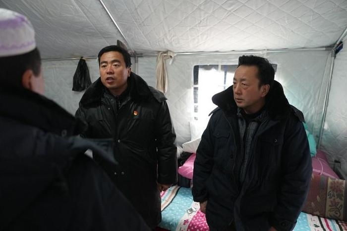 2023年12月22日，積石山縣大河家鎮(zhèn)大河村黨支部書記馬成忠（右二）在帳篷里和受災(zāi)群眾交流。新華社記者 陳斌 攝